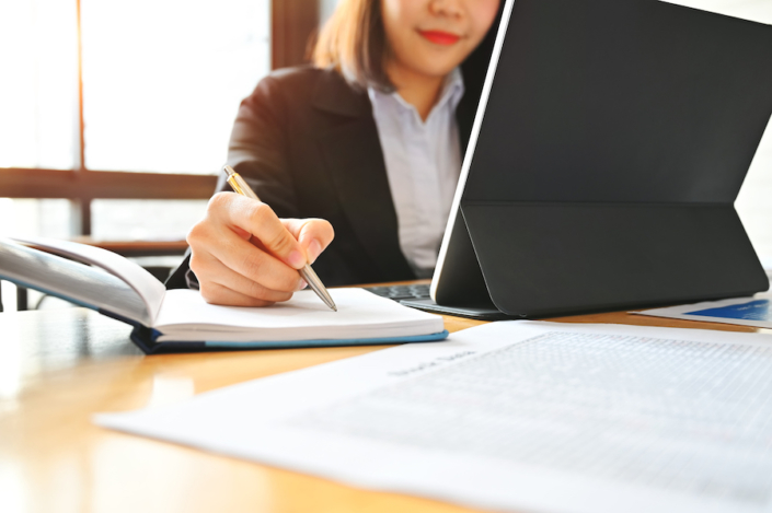 Audit business woman working with notebook and tablet on desk. Bookkeeping Clean Up Checklist